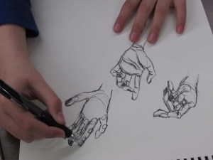 A young art student draws a variety of hand sketches.